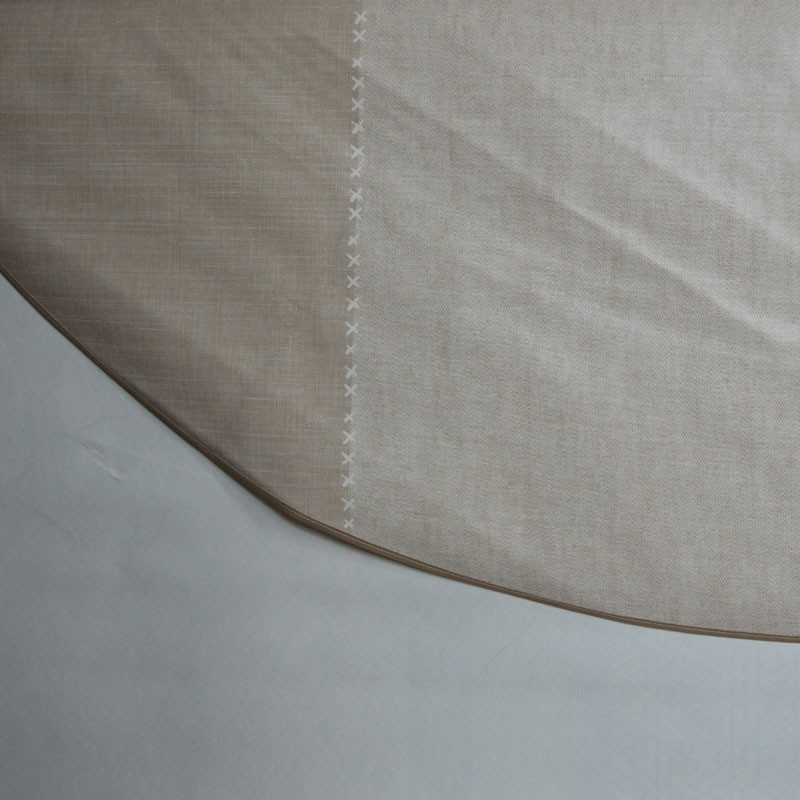 Toile cirée ronde pour 4 à 6 couverts finie par un biais à l'esprit "chemin de table" bordé par un point de croix