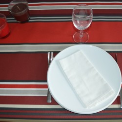Nappe en toile enduite à l'esprit basque avec ses rayures rouges, bordeaux et naturel