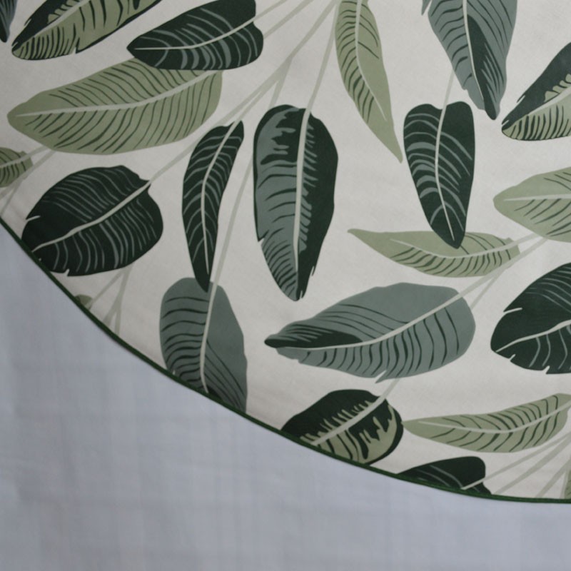 Toile cirée ronde, finie par un biais, pour 4 à 6 couverts, de larges feuilles vertes pour un esprit tropical