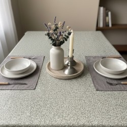 Toile cirée au mètre Rani, en 180 cm de largeur, un motif végétal délicat couleur crème sur fond taupe sur votre table...