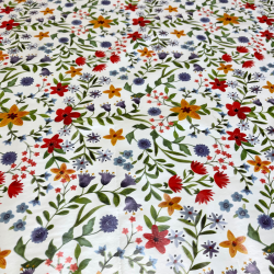 Toile cirée au mètre Renée, motif de fleurs sauvages avec des touches de rouge, jaune et violet viennent illuminer l'ensemble