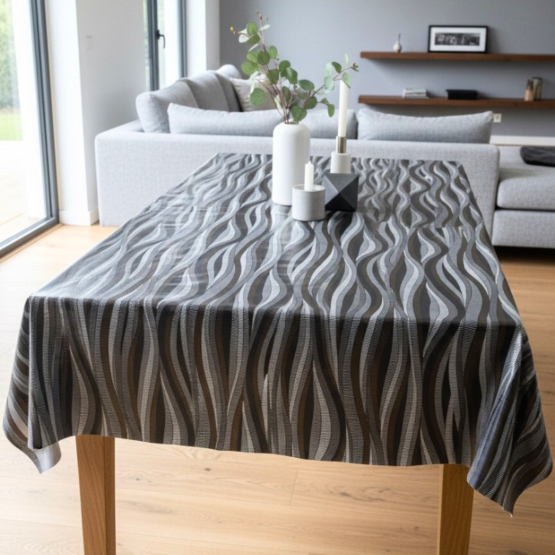 Toile cirée au mètre Gabrielle, un motif ondulé et graphique, composé de lignes noir profond et de touches de doré