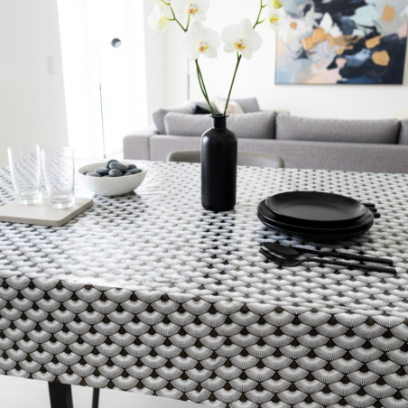 Toile cirée au mètre Élise, un motif répétitif en éventails stylisés blancs et noirs, rehaussés de délicates touches dorées